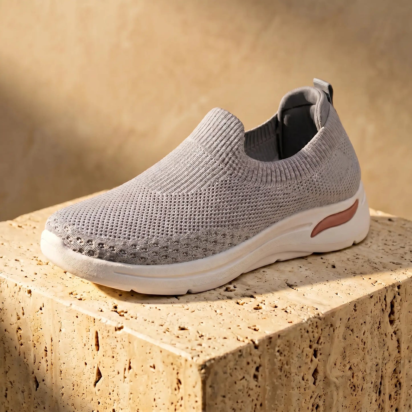 Zhivra women's Cloud Grey knit slip-on sneaker, showcasing breathable perforated upper, ribbed collar, and thick white wedge sole with a subtle peach accent.