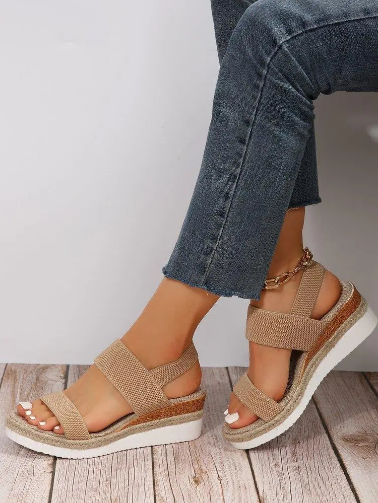 Zirath beige woven fabric espadrille wedge sandals worn by a model with blue denim jeans, featuring a fish-mouth toe and elasticated slingback strap for comfortable summer style.