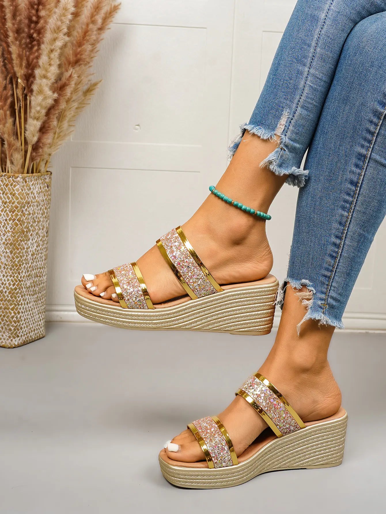 Women's Zlata metallic gold glitter wedge slide sandals with a fish-mouth peep toe, worn with distressed denim jeans against a studio background.