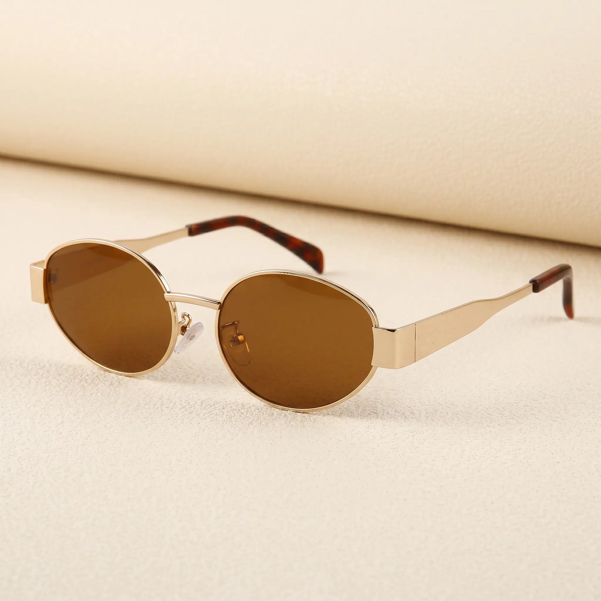 Gold and tortoiseshell Zokari vintage oval metal frame sunglasses with dark tinted lenses, shown at a three-quarter angle.