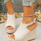 Model wearing Zoltan Earthy Beige peep-toe espadrille wedge sandals with jute-wrapped heel and buckle ankle strap, paired with distressed denim jeans.