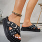 Women's black platform slide sandals with denim-like textile straps, densely covered in silver studs and featuring an ornate silver buckle, shown on a model's foot.