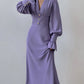 Elegant lilac chiffon midi dress with romantic V-neck, voluminous bishop sleeves, and pearl button details, shown worn by a model.
