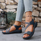 Zykla women's dark blue comfort sport sandals with criss-cross elastic straps and beige accents, shown on a model wearing light-wash jeans.