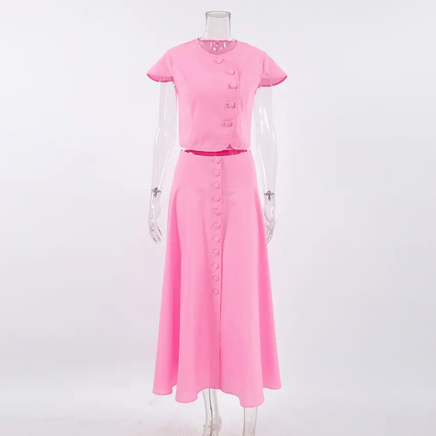 Zylia elegant pink cotton two-piece set featuring a cropped short-sleeve top and a button-front A-line midi skirt, displayed front view on a white background.