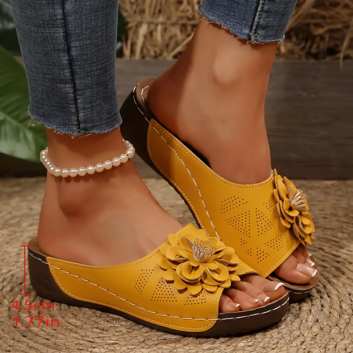 Sunny Marigold Zylia women's slip-on sandals with a dimensional floral embellishment and perforated strap, worn with jeans and a pearl anklet.