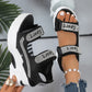 Zylos black mesh platform sandals adorned with sparkling "SPORT" rhinestone-embellished straps, shown on a foot with a pearl ankle bracelet and held by a hand showcasing a floral ring.