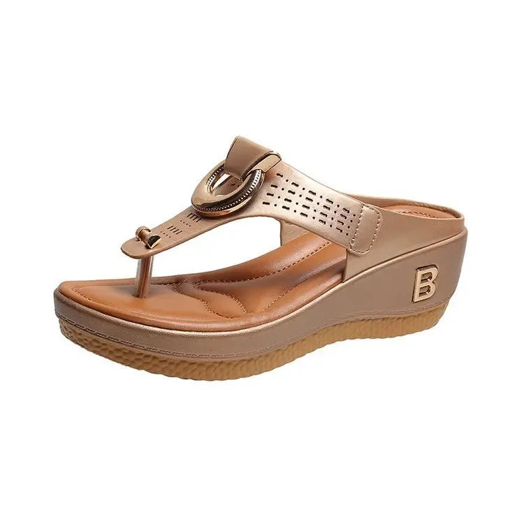 A single champagne-colored Zylos wedge thong sandal with gold ring hardware and perforated straps, shown from a three-quarter angle on a white background.