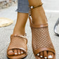 Close-up view of a woman's feet wearing cognac brown Zylos mesh and faux leather flat sandals with a buckle strap, styled with denim jeans.
