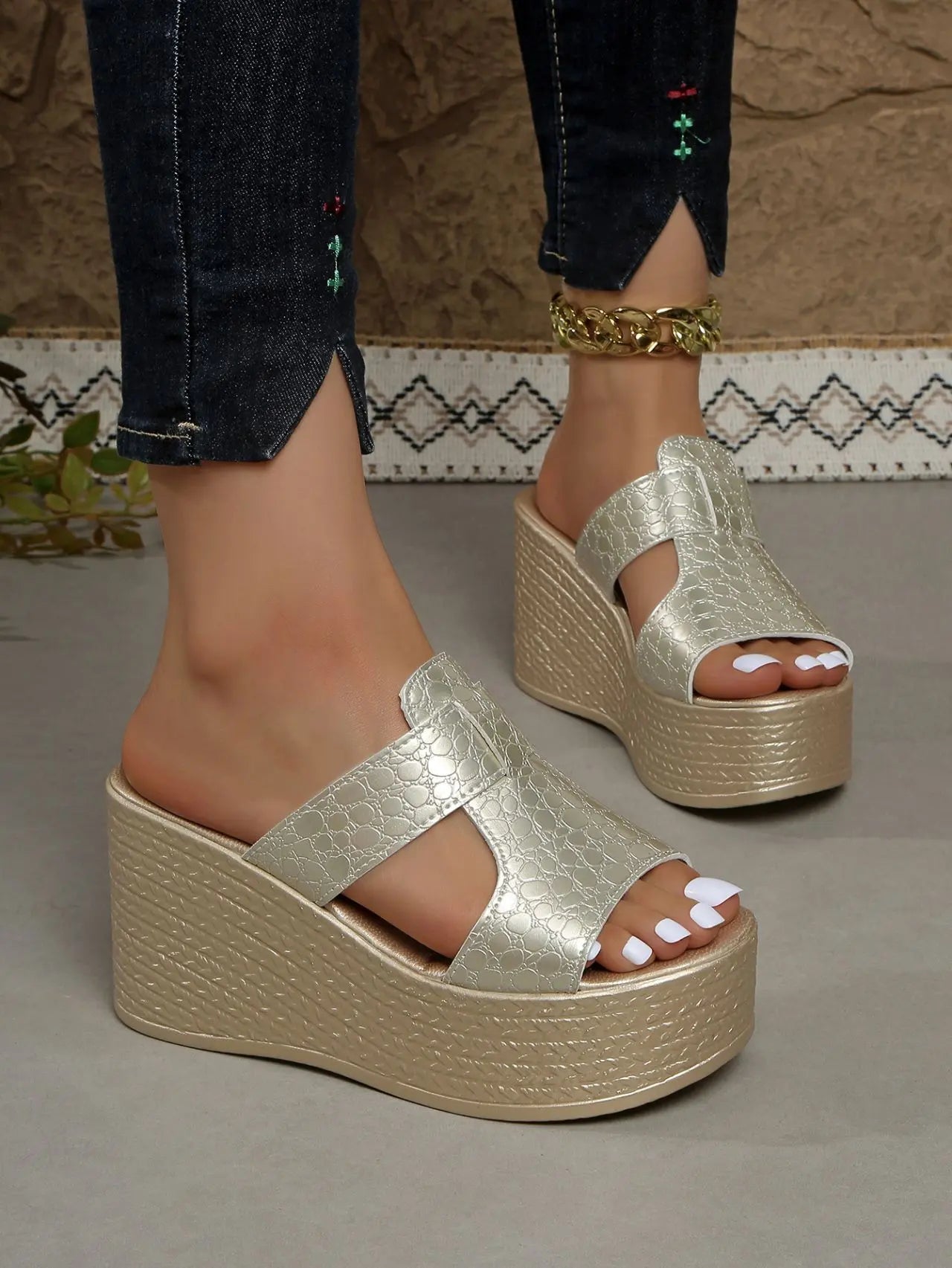 Zylos gold metallic embossed PU platform wedge sandals styled with dark wash jeans and a gold chain anklet.