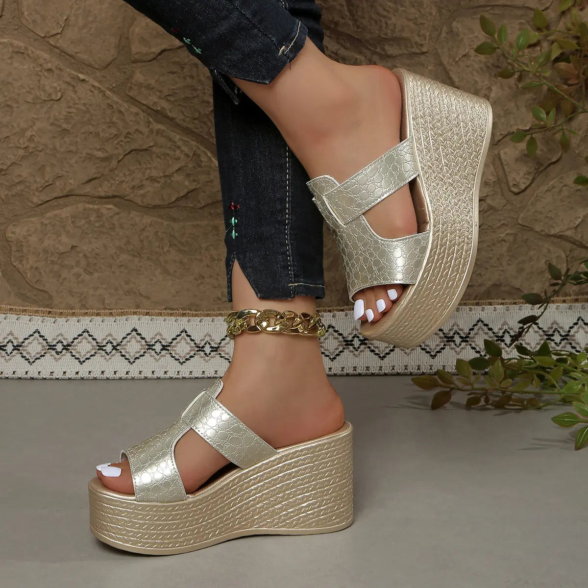 Zylos gold metallic embossed PU leather wedge sandals with a 10cm heel and 4cm platform, styled with dark denim jeans and a gold anklet.