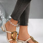 Creamy ivory Zylos women's slide sandals with a square toe, large gold oval buckle, and a comfortable 4.5cm block heel, shown on a model's feet.