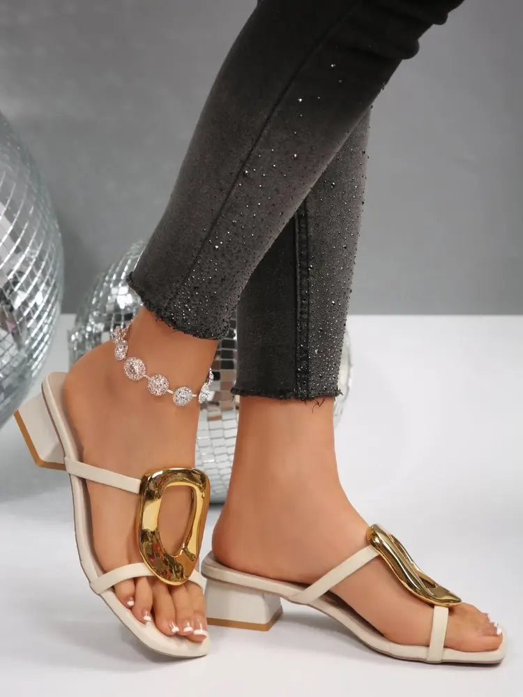 Creamy ivory Zylos women's slide sandals with a square toe, large gold oval buckle, and a comfortable 4.5cm block heel, shown on a model's feet.