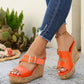 Zylos women's vibrant orange peep-toe wedge sandals styled with distressed denim jeans and a silver buckle strap, showcasing the multi-colored flecked cork wedge and rubber sole.