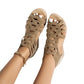 Golden sand Zylos rhinestone wedge sandals with Roman-style straps and a gold ankle chain, shown from a top-down view on model feet with white toenails.
