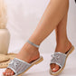 Zylos silver metallic mesh bow slides elegantly worn on a model's feet, showcasing the open-toe design and braided sole trim.