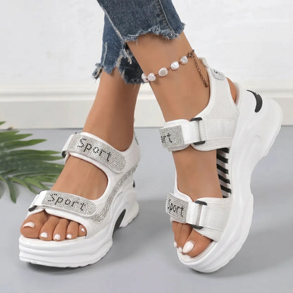 Luminous Pearl White Zylos sporty chic platform sandals with rhinestone-embellished straps and hook-and-loop closure, shown on feet with denim jeans.