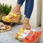 A woman's legs wearing yellow Zylos peep-toe wedge sandals with a multi-colored flecked cork wedge and silver buckle strap, styled with distressed denim jeans, alongside white and orange variants.