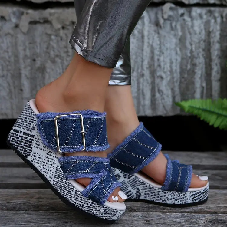 Women's Zylva distressed denim wedge sandals with frayed edges and a striking black and white newspaper print on the wedge, featuring a silver buckle closure.