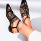 Black mesh pointed-toe heeled sandals with thin faux-leather straps and a low block heel, worn by a model on a white studio background. Elegant summer footwear.