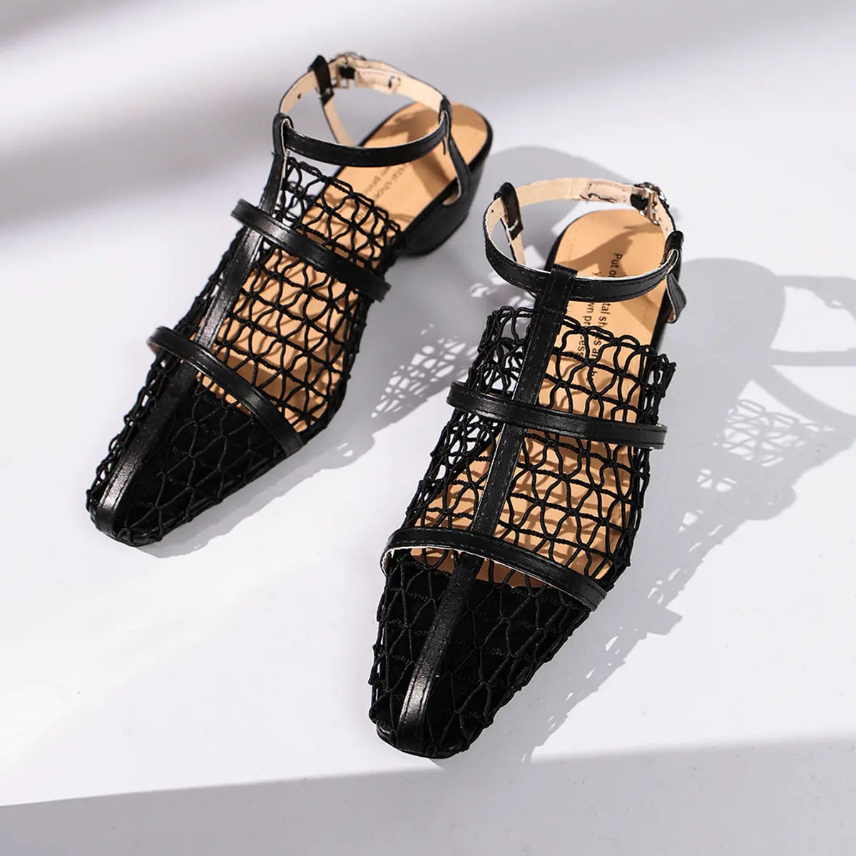 Zynthis black mesh heeled sandals featuring an elegant pointed toe, delicate woven straps, and a low block heel with an adjustable ankle strap.