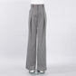 High-waisted Zyntra wide-leg trousers in a sophisticated grey hue, featuring sharp front pleats and a fluid drape, presented flat lay on a white studio background.