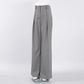 Zyntra elegant wide-leg trousers in a sophisticated cool grey hue, featuring a high-waist design and sharp front pleats for a fluid drape. Shown from the front on a clean white studio background.