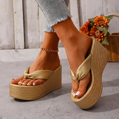 Women's Zyphra metallic champagne gold wedge platform flip-flops with a knotted PU leather strap and woven-textured base, shown on feet with denim jeans and an anklet.