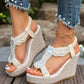 Close-up of embellished off-white bohemian wedge sandals worn with pearl-trimmed denim jeans, showcasing intricate pearl and crystal details and a textured wedge heel.