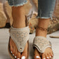 Zyra laser-cut platform thong sandals in a light beige suede-like PU material, worn by a model with white-painted toenails and distressed denim jeans, showcasing the cork-patterned footbed and gold buckle detail.