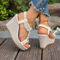 Close-up of off-white bohemian wedge sandals worn on feet, featuring pearl and crystal embellishments on the T-strap, textured linen-like wedge, and elastic ankle strap. A gold anklet is visible.